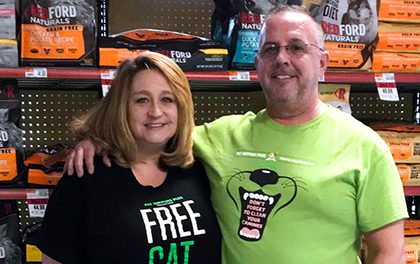 Franchise owners stand in front of kibble in store