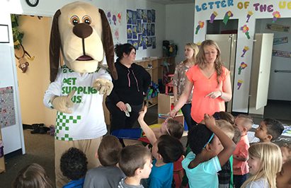 The PSP mascott is interacting with kids in a classroom